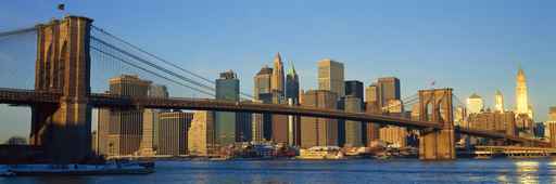 Panoramic view of Brooklyn Bridge and East River at sunrise with New York City, NY skyline post 9/11 view