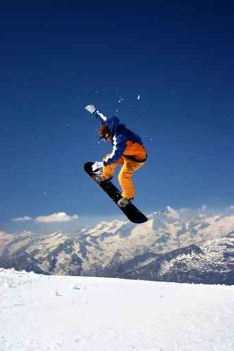snowboarder in orange jumping high - winter mountains action sce