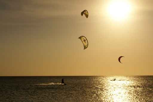 Kitesurfers silhouettes against sunset