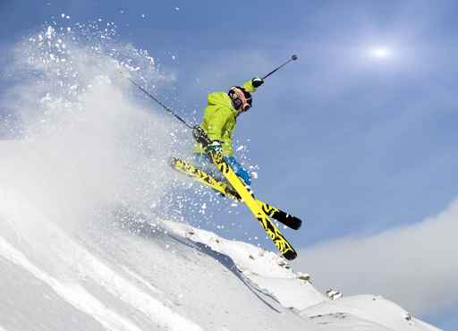 Jugendlicher Skifahrer springt im Tiefschnee