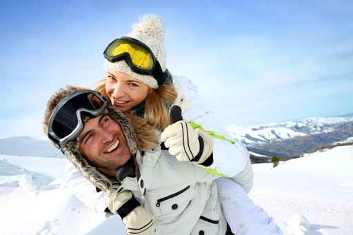 Skier at the mountain giving piggyback ride to girlfriend