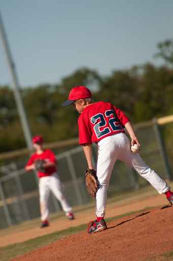 Little league baseball pitcher looking at batter.