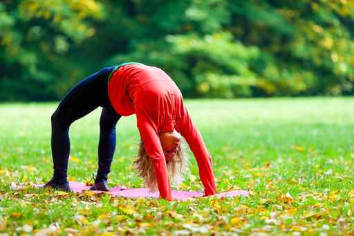 Young woman exercising yoga autumn